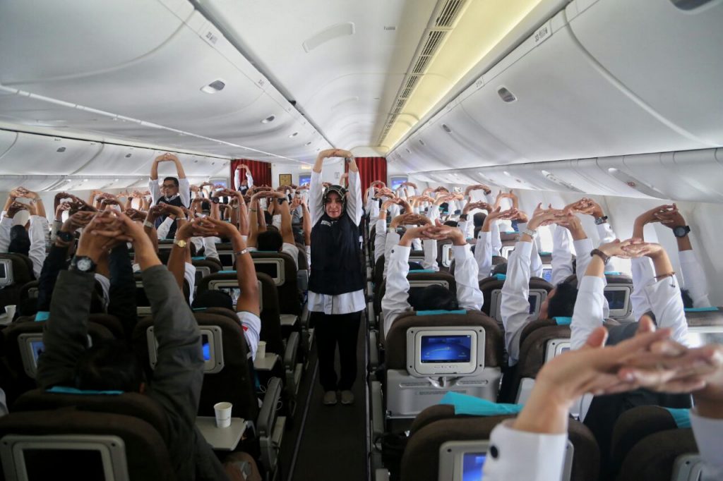 Tim Kesehatan Kemenkes Pimpin Petugas Senam Peregangan di Pesawat